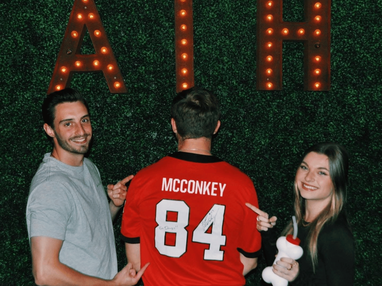 Two people at the Silver Dollar Bar point to a UGA jersey.